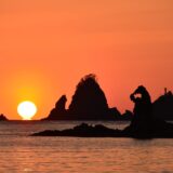 ゴジラ岩と夕陽（秋田県）